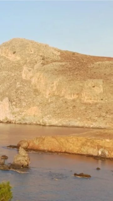 Olympia Yoga: hero του website με θάλασσα και βράχια στη Λέντα